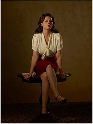 Agentica Carter Hailee Etvell kao Peggie Carter u crvenoj suknji s olovkom i bijeloj bluzi s prekriženim nogama fotografija od 8 do